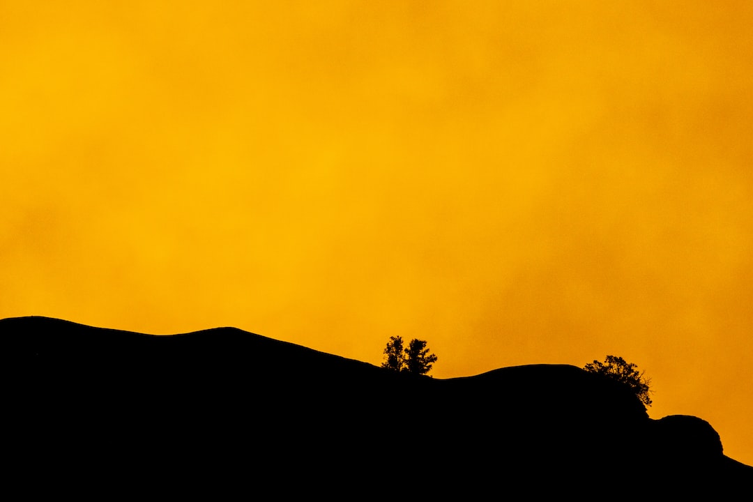 Silhouette of a mountain in front of a a yellow sunset-lit sky