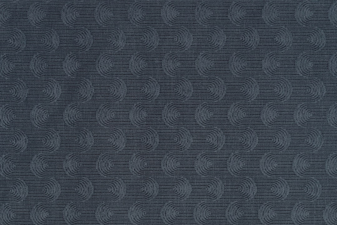 Photo of a midnight navy fabric swatch with repeating wavy swirls. Perfect for computer and phone wallpapers.