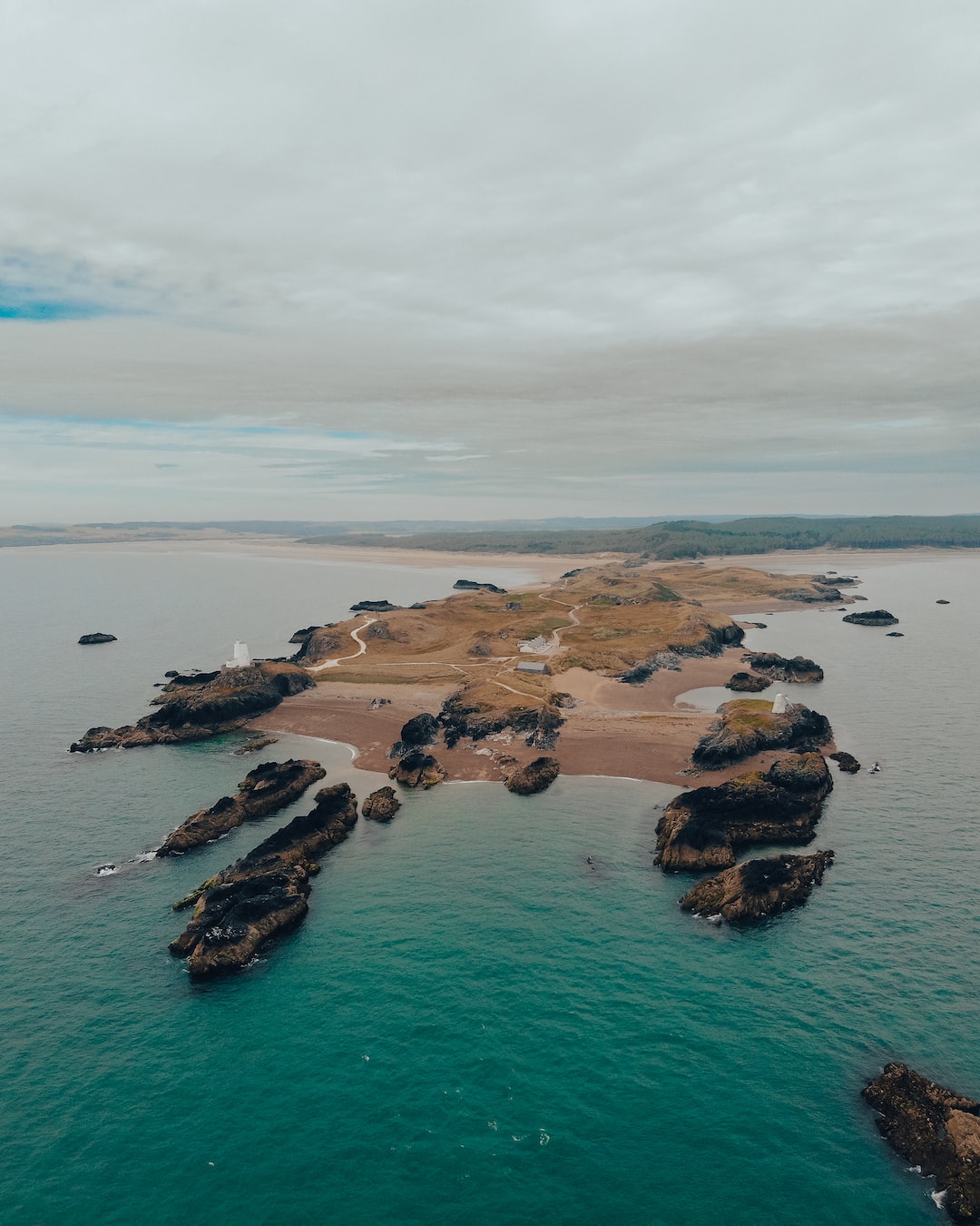 Vertical panorama photograph of an island landscape surrounded by blue water