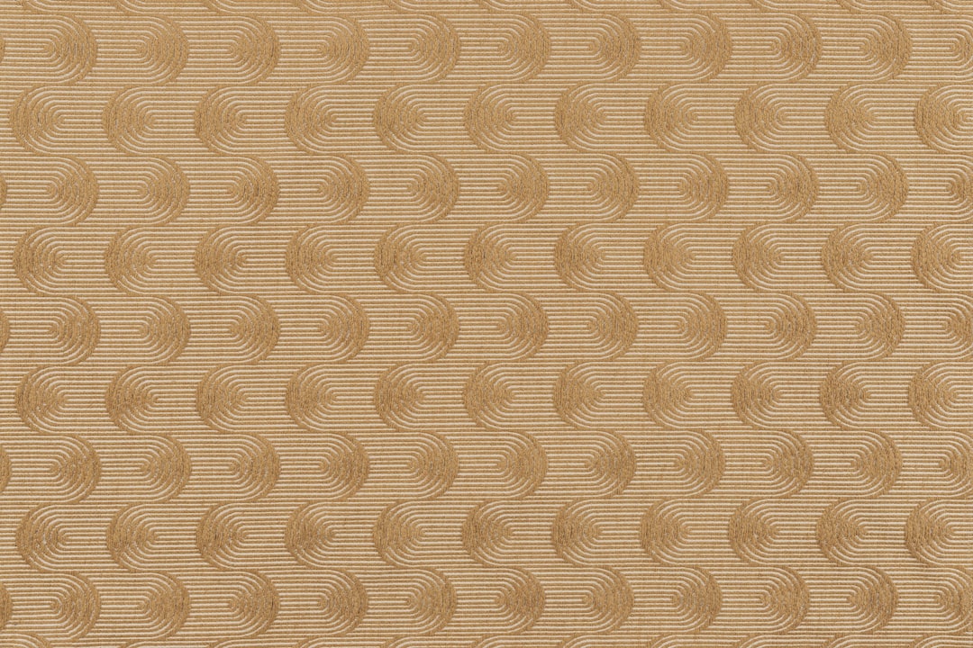 Photo of a saffron fabric swatch with repeating wavy swirls. Perfect for computer and phone wallpapers.