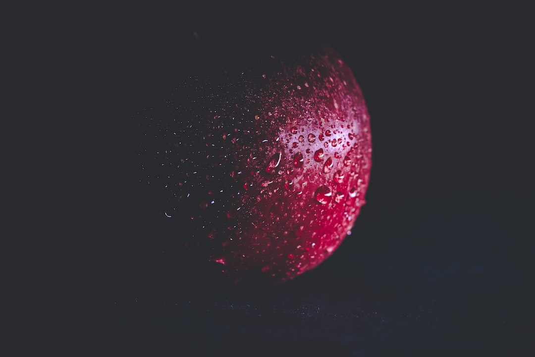 A red colour apple on a black background. Wallpaper material. Mobile wallpaper. Desktop wallpaper.