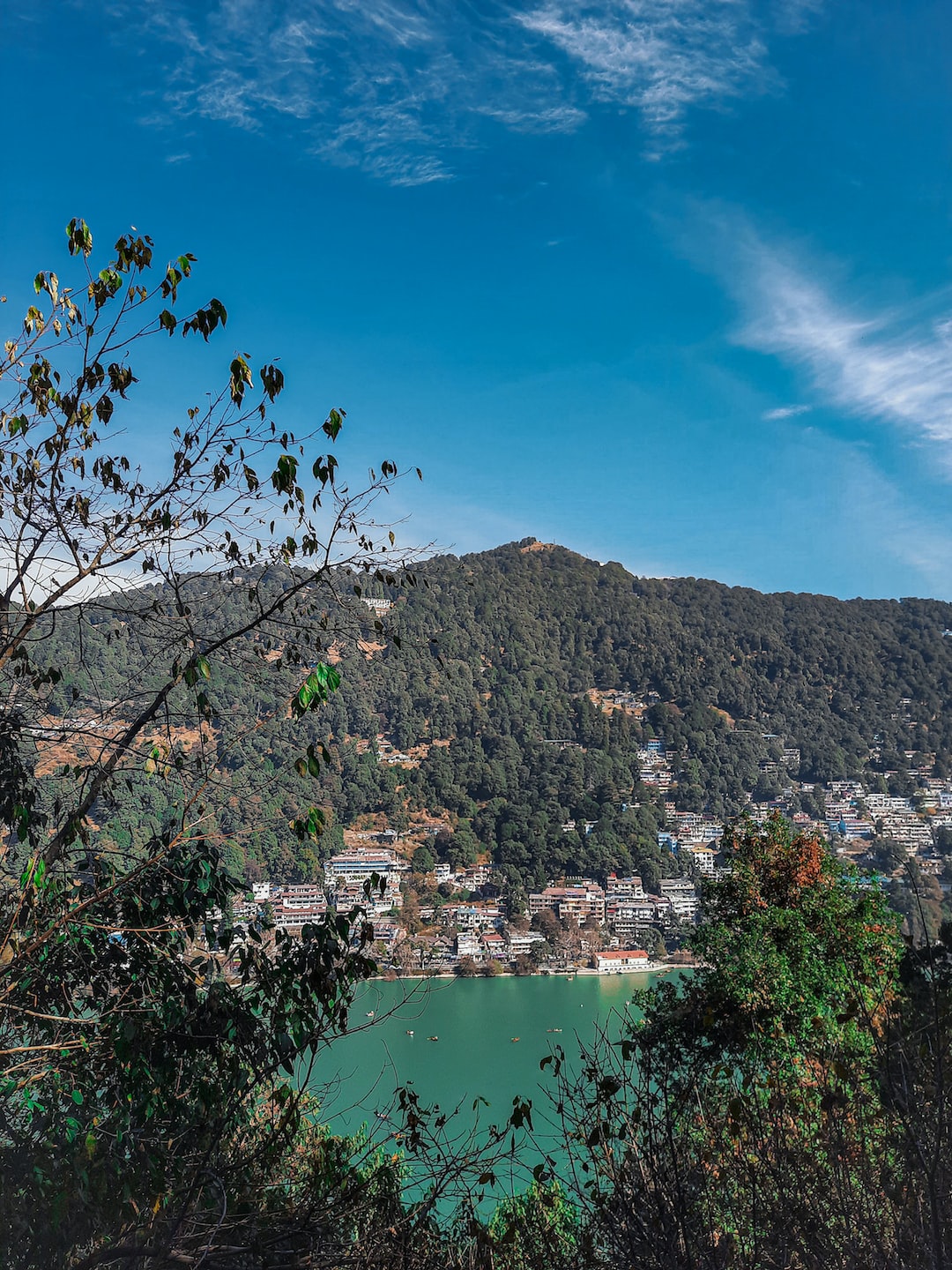 Top view of beautiful blue Nainital Lake and the Mall Road from the hills on blue sky.