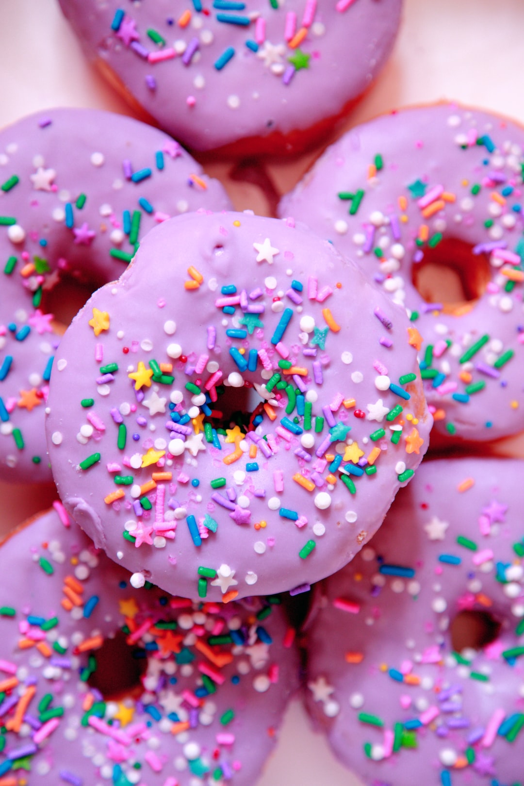 Purple donuts with colorful sprinkles.