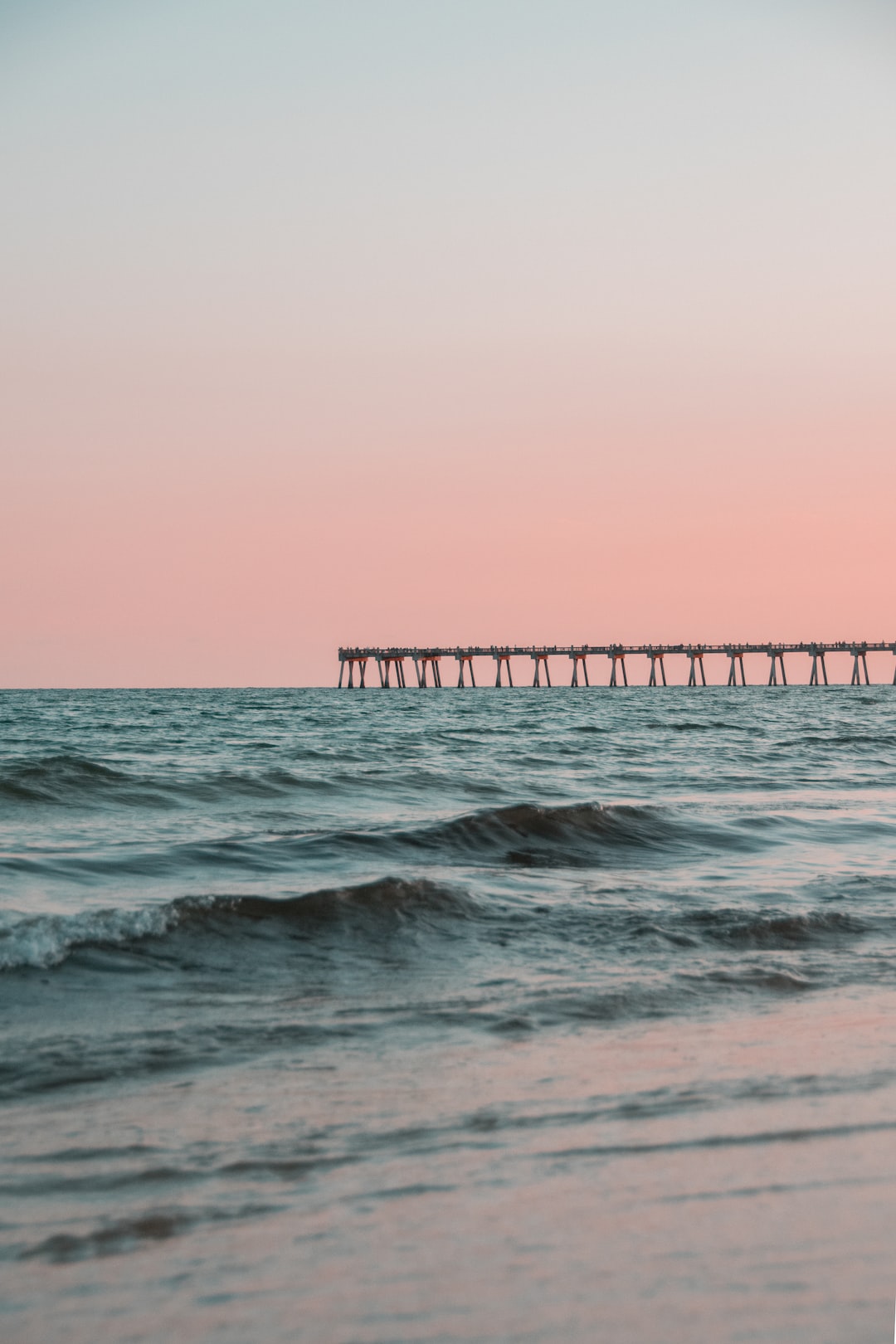 Clean photo of a pier at the beach.