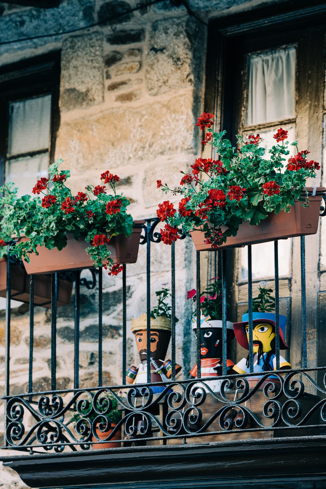 A cute balcony with geraniums and interesting flowerpots in Puebla de Sanabria, Spain