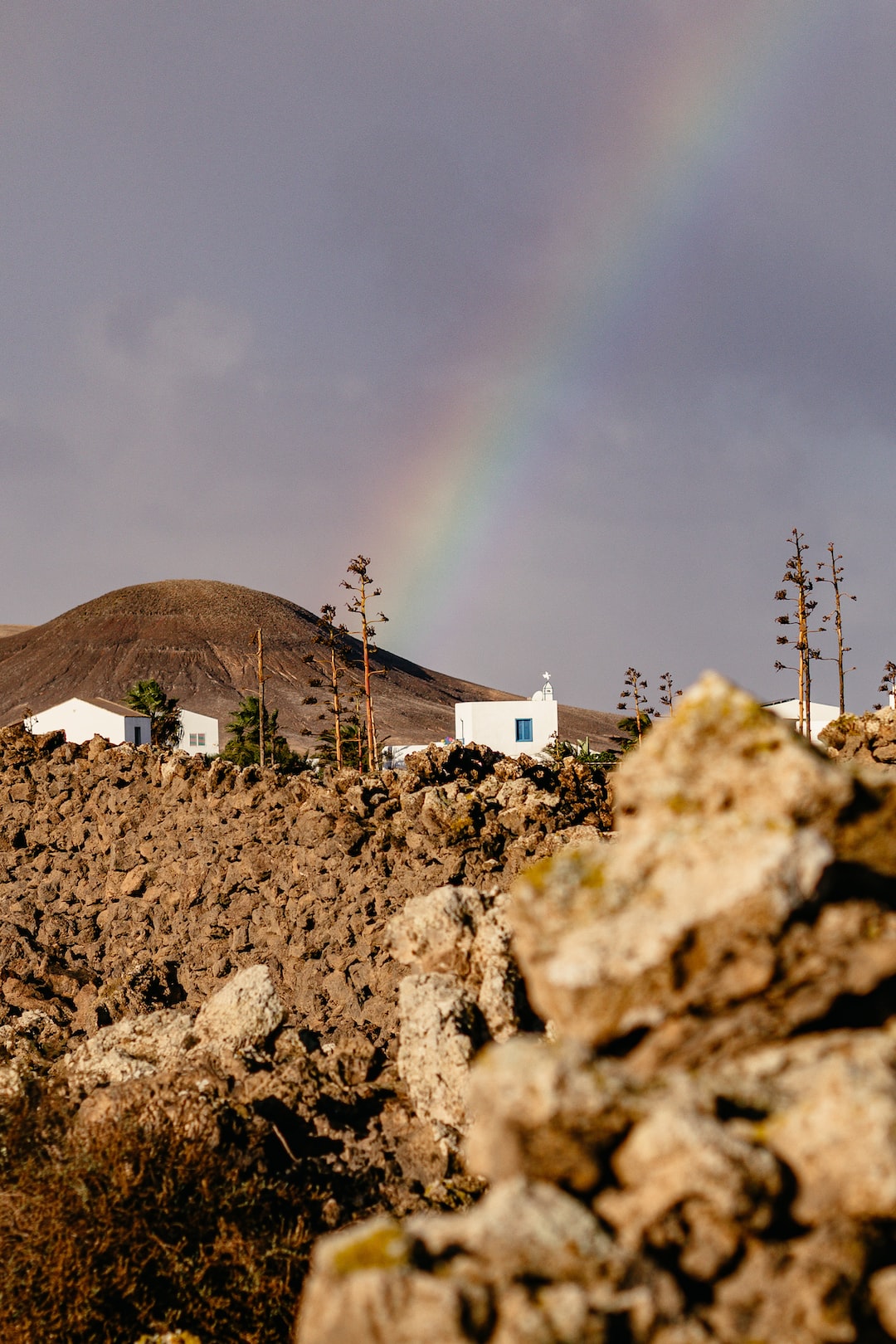 rainbow over a spanish town and the hills of fuerteventura