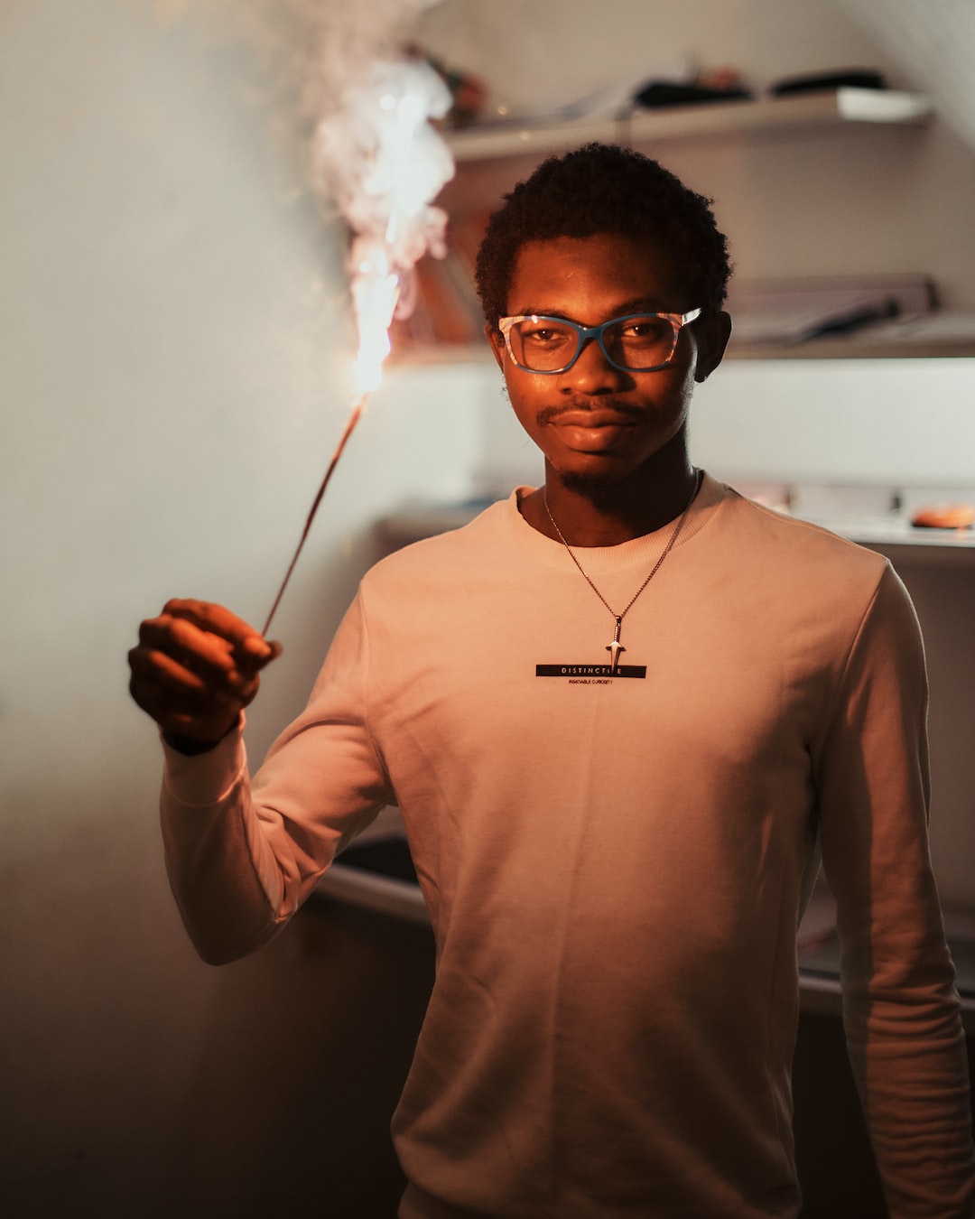 Black African man holding a sparkler to celebrate the new year.