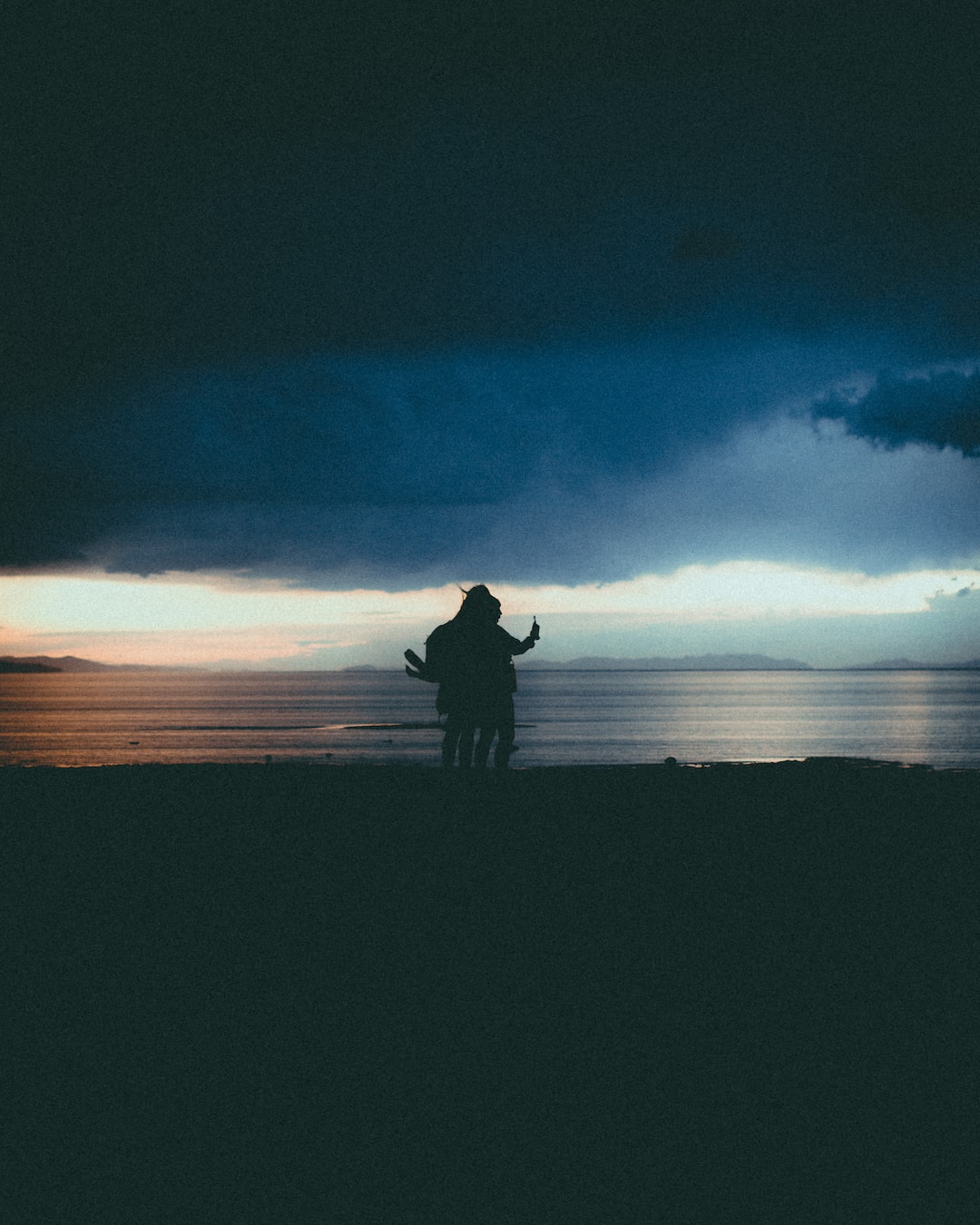 two girls standing near a lake