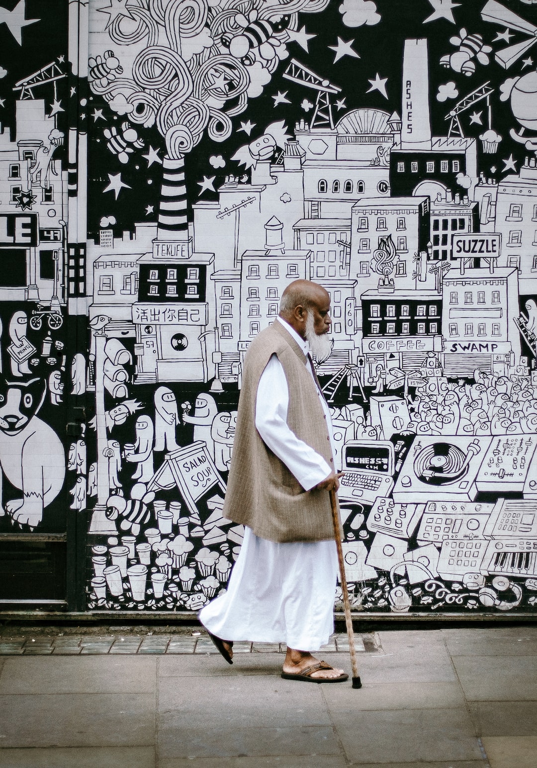 Man with stick on Brick lane