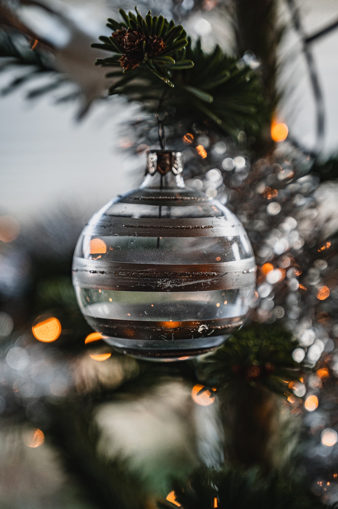 A scratched Christmas ornament hanging in the Chirstmas tree.