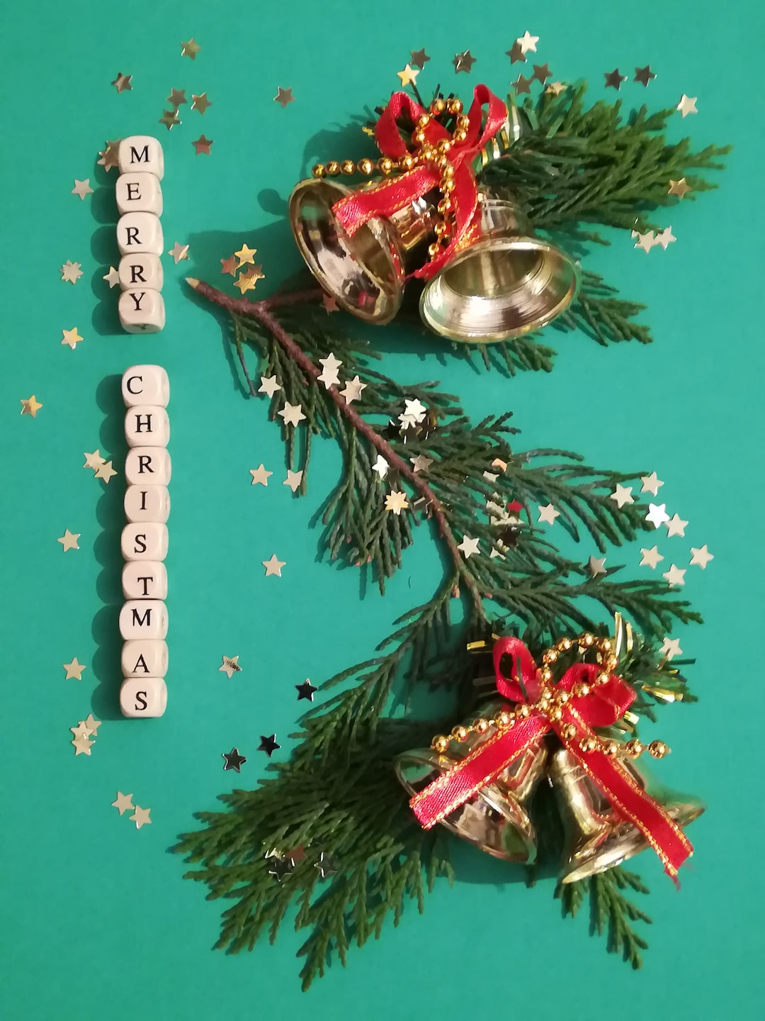 Christmas bells on tree branch with stars and Merry Christmas wishes