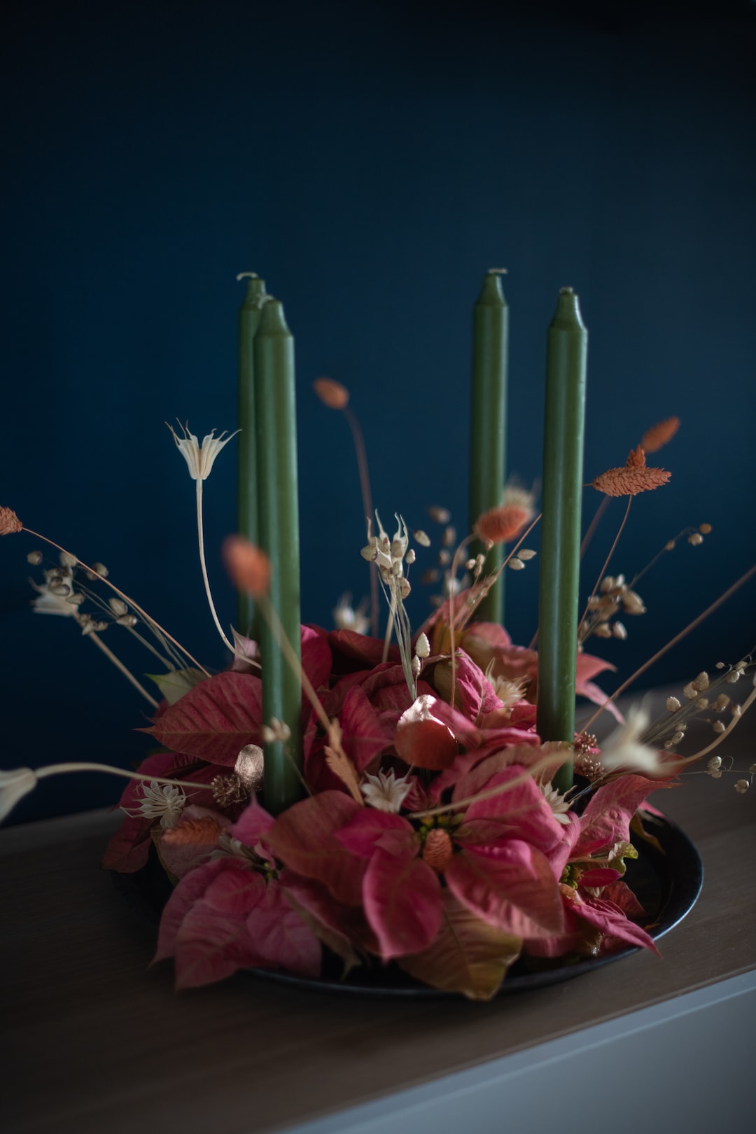 Stylish Christmas decoration, on light wood counter. Advent wreath in pale pinks and greens.