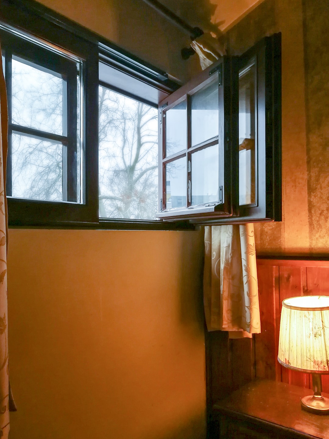 Cozy room with open window and lamp on the table