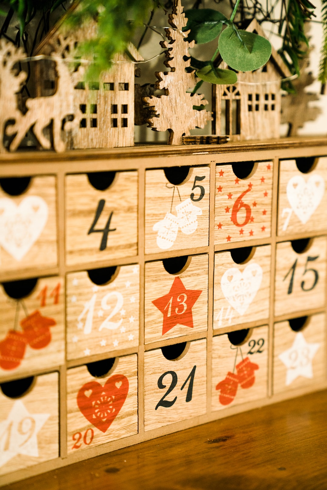 A lovely Chrismtas calendar on a shelf with holiday decorations in the background.