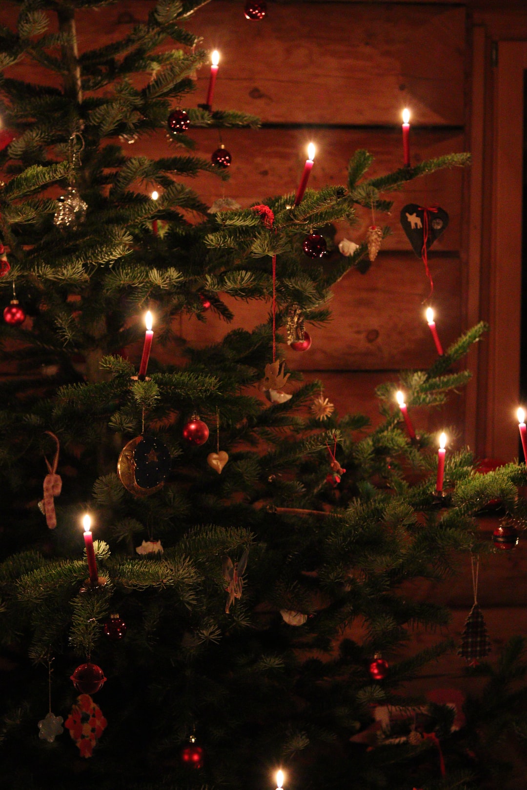 Christmas tree in a log cabin with decorations and candles