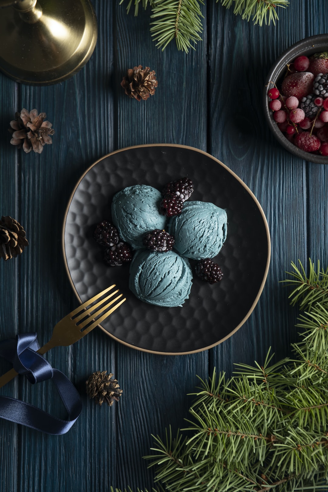 Close-up of a dish with three scoops of pistachio ice cream on a wooden table