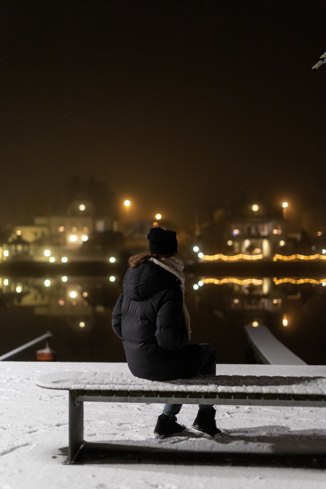 Woman sitting on bench after snowfall