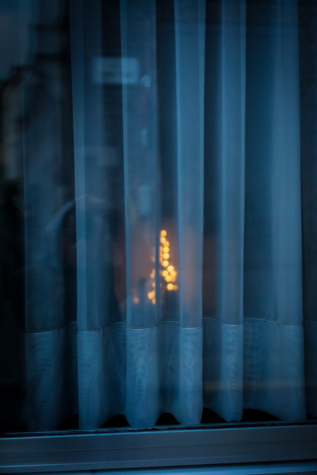 Cozy Christmas lights shining trough window curtain in Ghent, Belgium