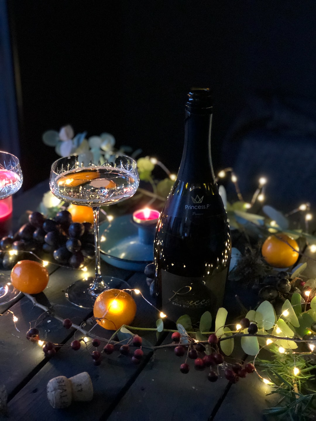 A bottle of Prosecco and a coupe on a sparkling decorated Christmas table 