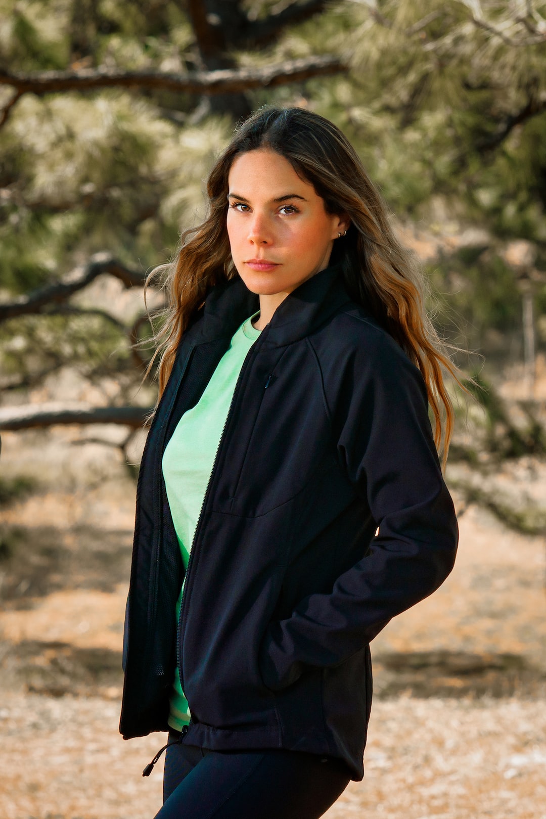 Woman posing for a portrait photo wearing a sport jacket in the forest