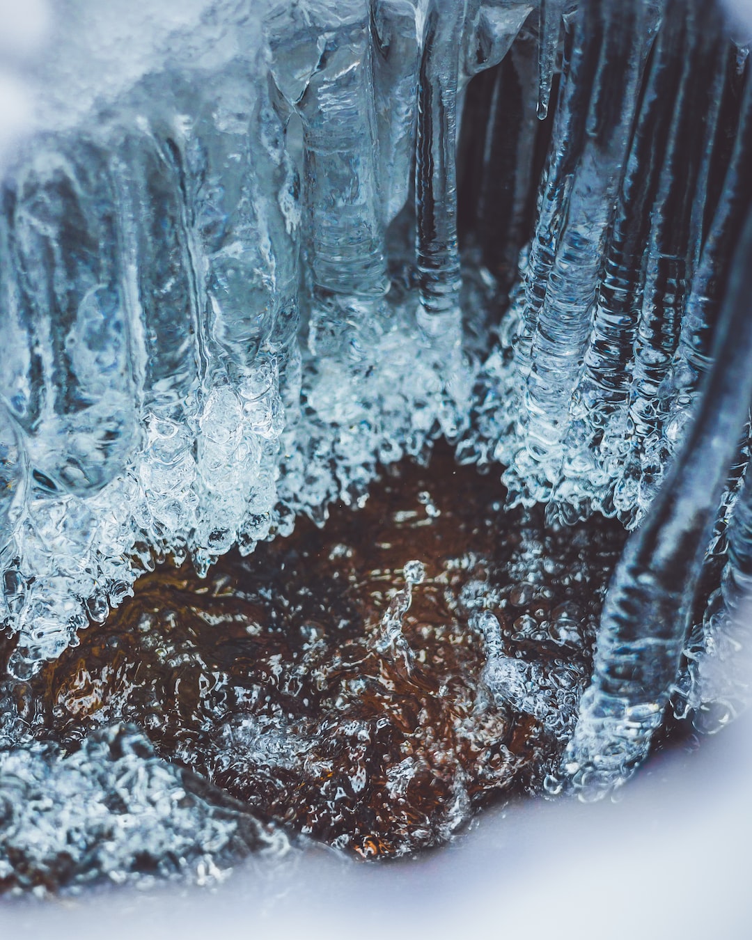 Ice forms between a running river and snow creating a beautiful ice cave