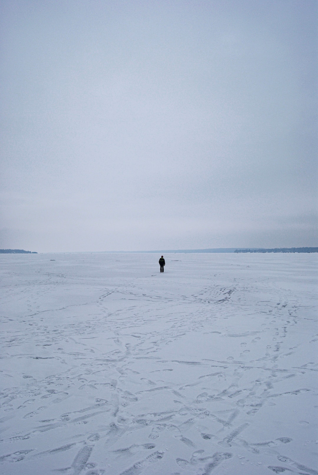 Solitary figure on frozen lake in winter