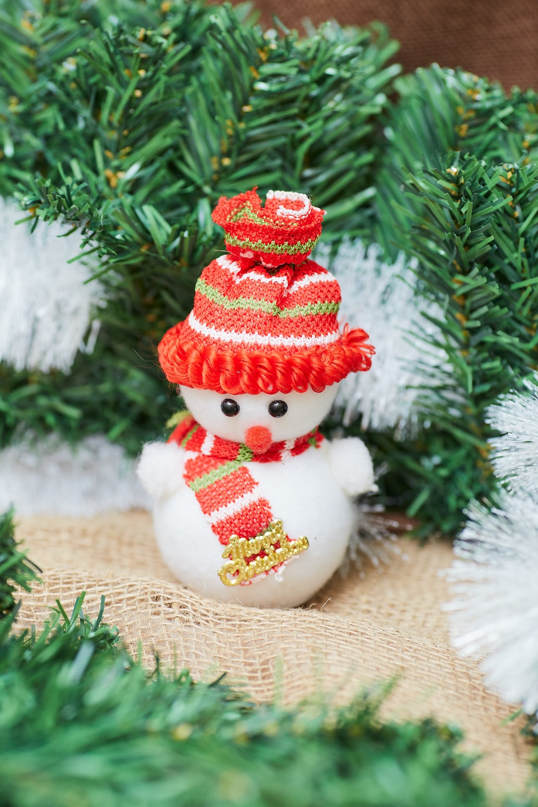 Toy snowman against the background of artificial spruce branches