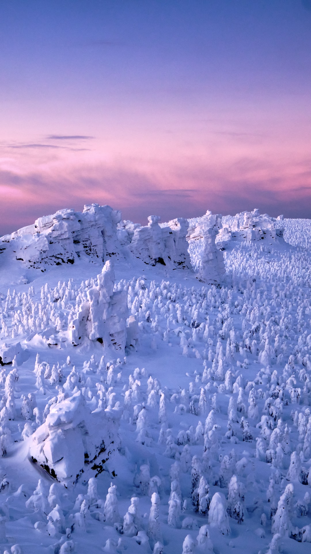 Winter dawn over the snow-covered and ice-covered mountains of the Urals. Mount Pomyanyenny Kamen