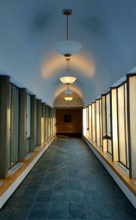 Hallway with light from windows and chandeliers