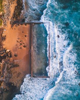 An ocean pool acting as a break wall for the cliffs beside it