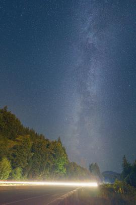 Vertical Shot of the Milky Way Arch near Squamish, BC featuring light trails from cars on the highway. Taken during the Peresid meteor showers in 2021.