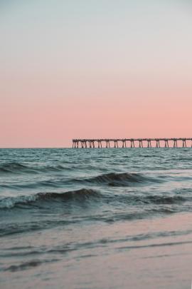 Clean photo of a pier at the beach.