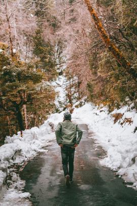 man hiking on beautiful snow covered trails on a mountain.