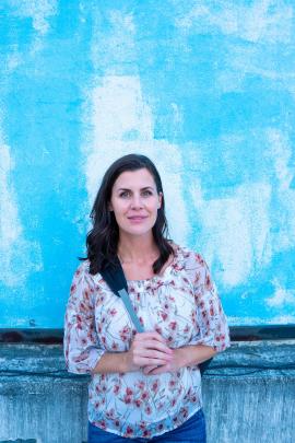 Beautiful woman standing near blue wall in Rio de Janeiro, Brazil. 