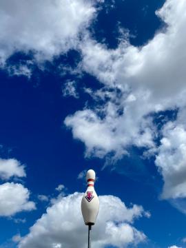 Bowling pin against a cloudy sky