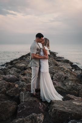 Couple kissing each other on the beach for the wedding.