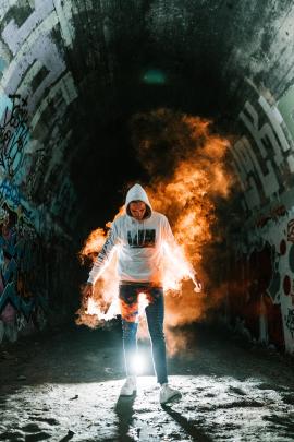 Man in dark tunnel holding flare. Follow me on Insta @bailey.shoots