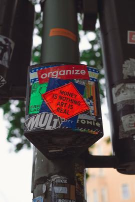 Money is nothing – Art is real. Urban street art. Sticker at traffic lights. Made with Canon 5d Mark III and vintage analog lens Leica Summicron-R 2.0 50mm.