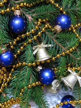 A Christmas tree decorated with blue balls and gold bells