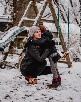 At the playground on a snowy day with mom and son