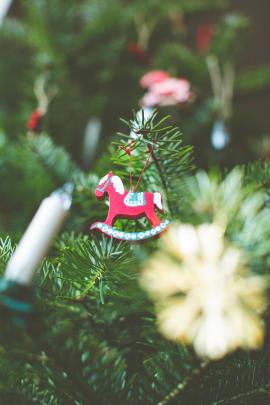 Festive christmas tree decoration with a handcraft wooden rocking horse