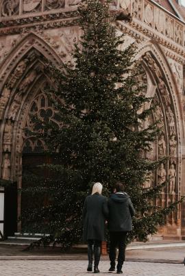  A couple walking towards a large Christmas tree in the Center of Nürnberg.