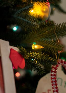 Single yellow light bulb on a Christmas tree