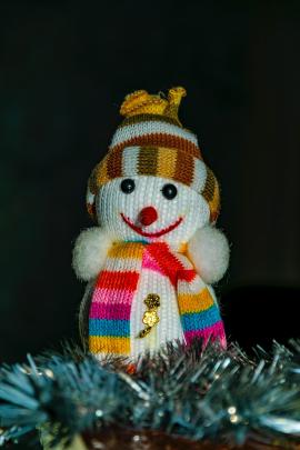 Little knitted toy snowman waits for the winter holidays to give joy to everyone