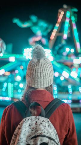 A girl stood next to a carnival ride