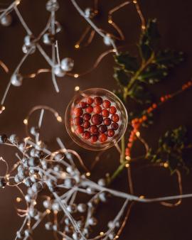 Overhead View of Cranberry Cocktail Surrounded by Lights and Holly