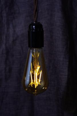 A light bulb is lit on a black background