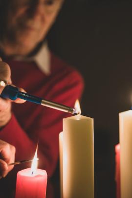 Man lighting a candle at Christmas