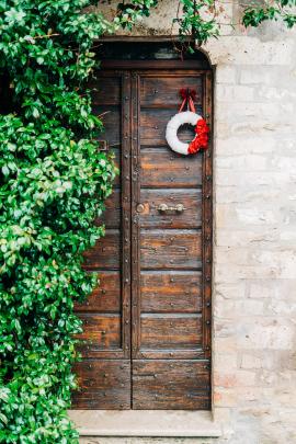 A lovely understated Christmas decoration on an old fashioned wooden door in Italy