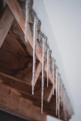 ice spikes hanging off a rooftop